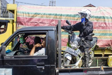 Pemudik naikkan motor di atas mobil bak terbuka