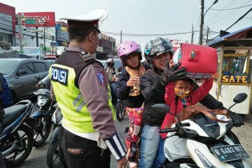 Pemudik motor membawa barang berlebihan melintas Tangerang siang hari