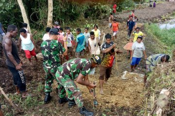 Yonif 725/WRG bersama warga perlebar jalan penghubung antarkampung