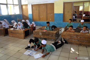 Siswa terpaksa belajar di lantai karena sekolah kekurangan bangku dan meja