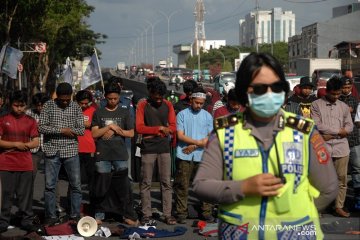 Mahasiswa sholat di jalan