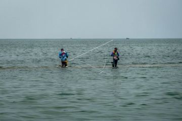 Memancing ikan di atas struktur dam pemecah gelombang