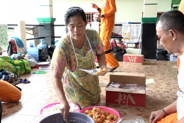 Warga bantu memasak makanan untuk korban banjir