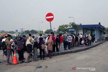 Calon penumpang mengular saat antre naik TransJakarta