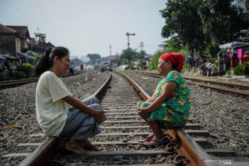 Berjemur di tengah rel kereta api