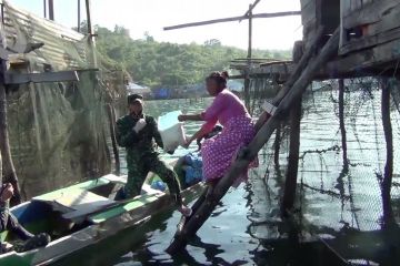 Aparat bagikan sembako gratis ke nelayan pesisir pakai perahu