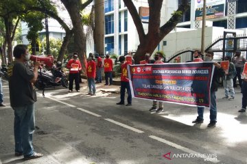 Para pekerja menjaga jarak aman dalam unjuk rasa Hari Buruh di Medan