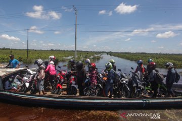 Warga seberangi banjir di jalur trans Kalimantan dengan perahu mesin