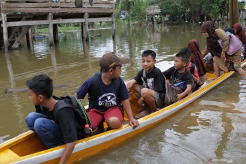 Anak-anak belajar kelompok di tengah banjir melanda