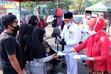 Polresta Sidoarjo kenakan pakaian pejuang sembari bagikan masker