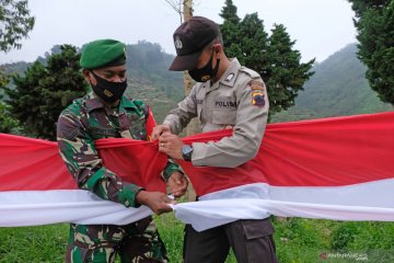 Pembentangan bendera merah putih untuk soliditas TNI dan Polri