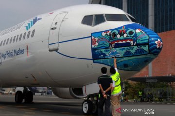 Gambar masker bertema Indonesia Pride di moncong pesawat Garuda Indonesia