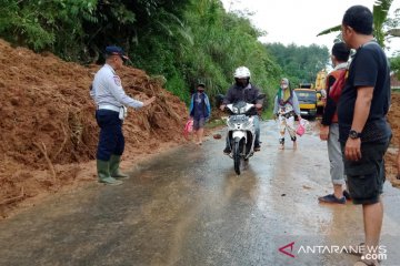 Petugas gabungan BPBD Cianjur membuka jalur tertutup longsor