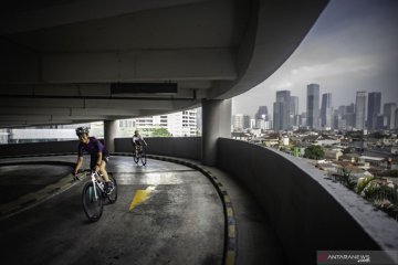 Warga bersepeda di jalan melingkar gedung parkir