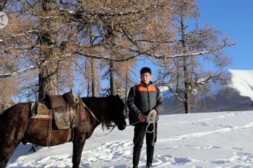 Kurir tunggangi kuda lewati area bersalju demi antar paket di Xinjiang