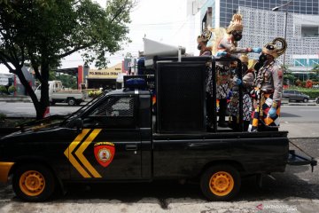 Polisi bagi masker dengan kostum wayang