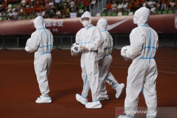 Panitia pertandingan kenakan APD saat laga kualifikasi Piala Dunia antara China vs Guam