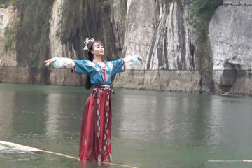 Seorang gadis menari di atas sebatang bambu menyusuri sungai