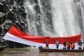 Komunitas wisata Subulussalam kibarkan bendera raksasa di air terjun