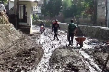 Petugas dan warga evakuasi material sisa banjir di Cimahi