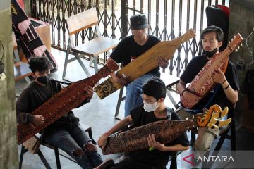 Berlatih bermain gitar tradisional Suku Dayak