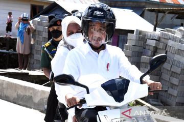 Presiden dan Ibu Negara berboncengan kendarai sepeda motor listrik