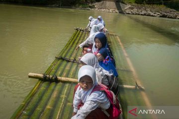 Jembatan gantung putus, siswa seberangi sungai naik rakit bambu