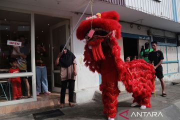 Barongsai beratraksi untuk mendapatkan angpao pemilik toko