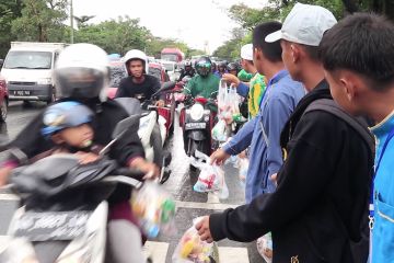 Guru dan pelajar membagikan paket makanan di Haul Guru Sekumpul