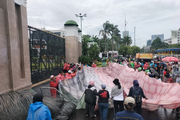 Ratusan PRT bentangkan serbet raksasa saat demonstrasi di gedung DPR