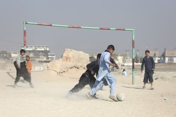 Kegembiraan anak Afghanistan bermain sepak bola di lapangan berdebu