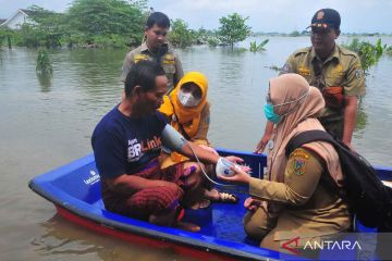 Petugas medis periksa kesehatan warga korban banjir di atas perahu