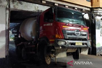 Truk molen tersangkut di kolong jembatan kereta di Matraman