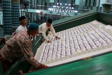 Petugas membalik lembaran Al Quran raksasa di Masjid Agung Baiturrahman