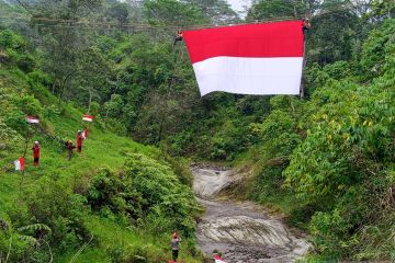 Pengibaran bendera merah putih di atas sungai kaki Gunung Merapi