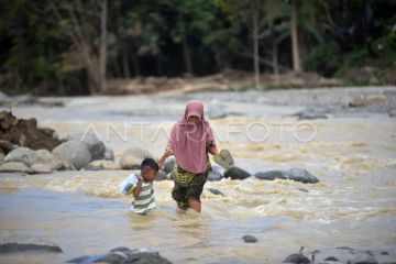 Warga menyeberangi sungai Batang Kuranji Padang