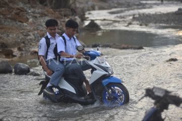 Warga menyeberangi sungai di Padang