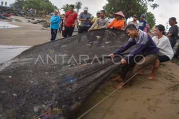 Nelayan menjaring sampah laut di Padang