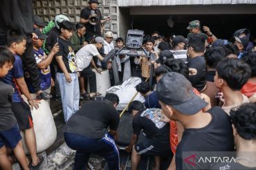 Massa bawa keluar barang milik Ahmad Sahroni dari rumahnya di kawasan Tanjung Priok