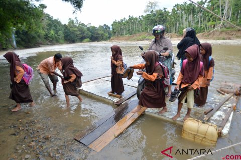 Akibat jembatan ambruk, warga desa Siro menggunakan rakit untuk menyeberang
