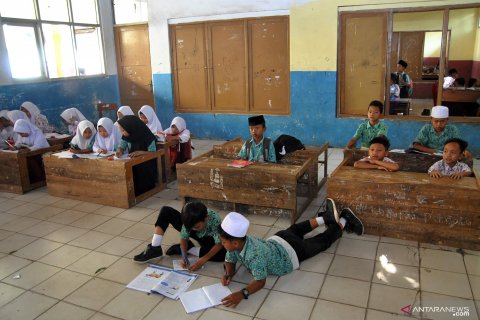 Siswa terpaksa belajar di lantai karena sekolah kekurangan bangku dan meja