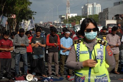Mahasiswa sholat di jalan