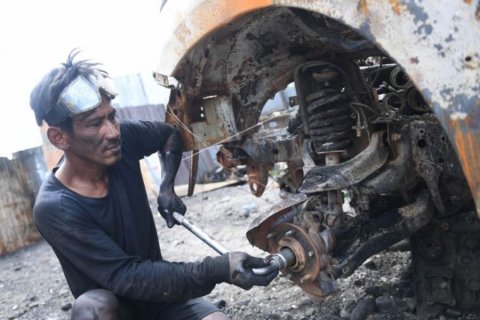 Mengumpulkan onderdil dari mobil yang dibakar pendemo