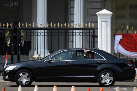 Presiden Jokowi melambaikan tangan kepada warga saat menuju ke lokasi pelantikan