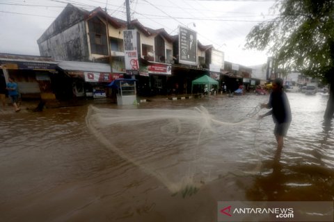 Menjaring ikan di jalan raya saat banjir di Banda Aceh
