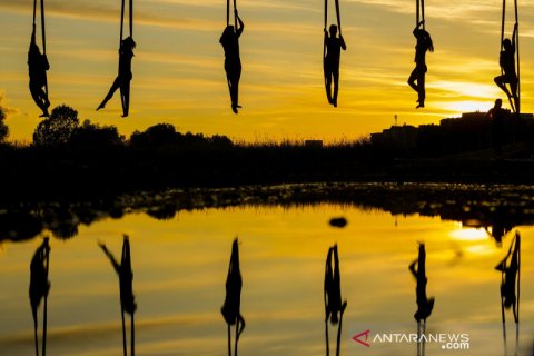 Aksi kelompok sirkus menari bergelantungan di jembatan