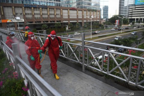 Penyemprotan cairan disinfektan di JPO dan halte bus