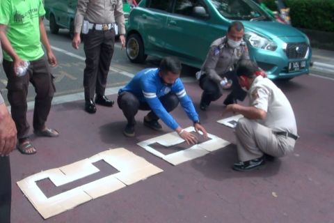 Pengendara motor berjaga jarak di lampu merah