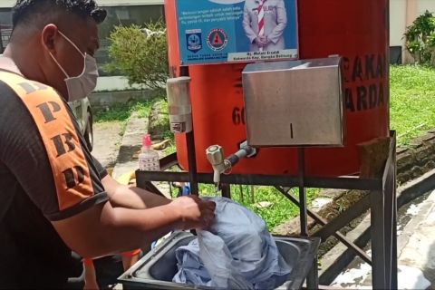 Petugas cuci ulang hazmat agar tetap bisa jalankan pemakaman