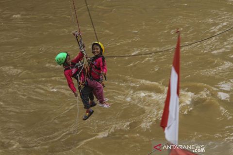 Wahana permainan lompat dari jembatan di atas sungai Ciliwung